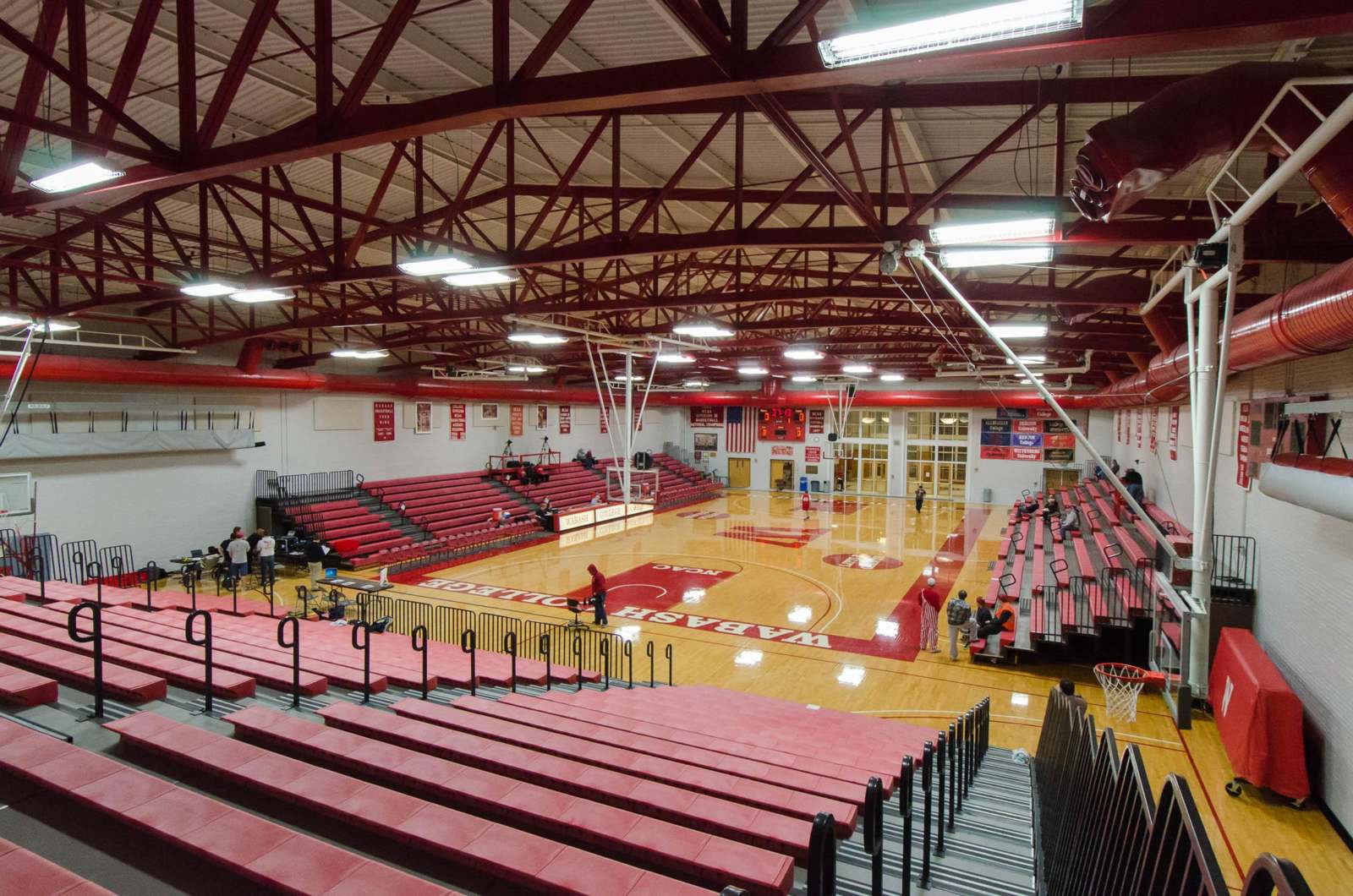 a basketball court with red seats and people in the back