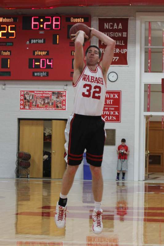 a man in a basketball uniform jumping up to throw a ball