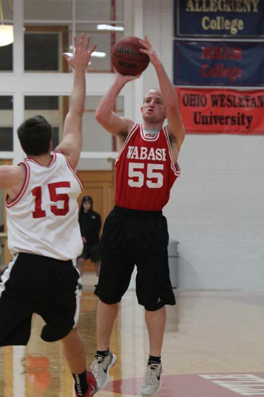 a man in a red shirt and black shorts playing basketball