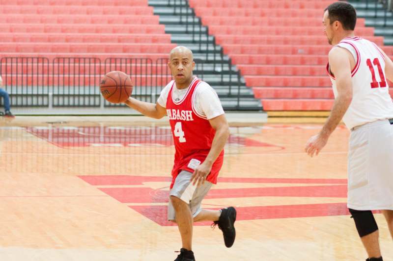 a man in a red uniform dribbling a basketball