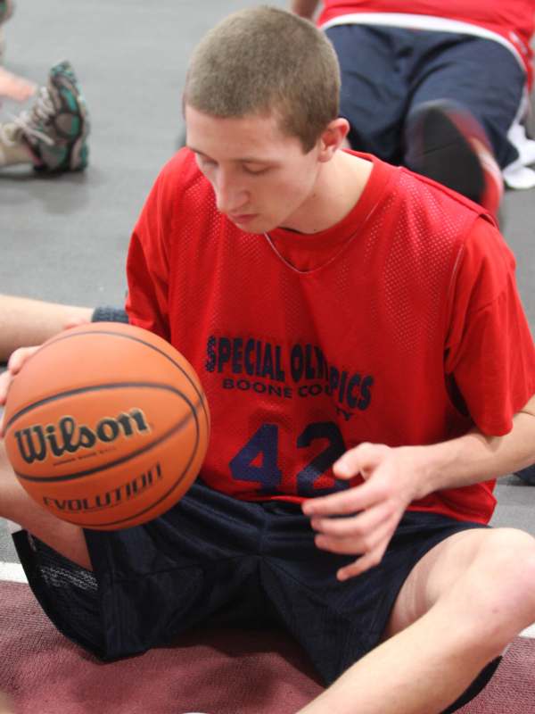 a man sitting on the floor with a basketball