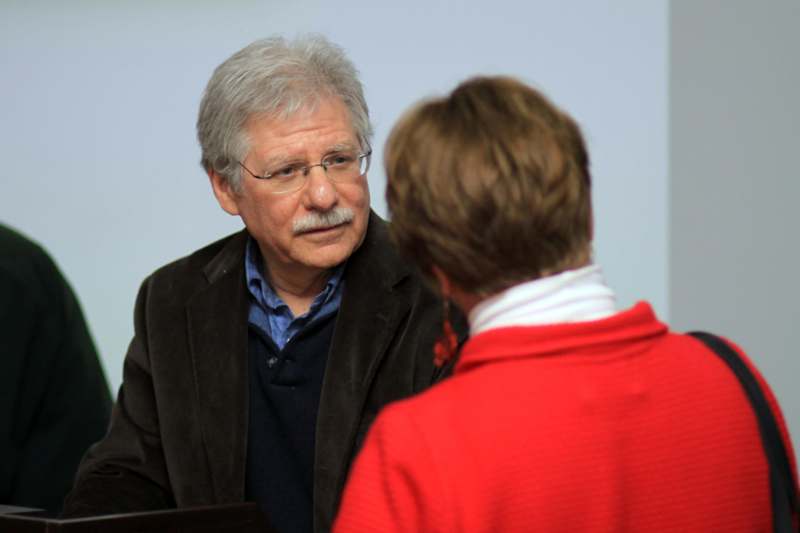 a man in a red sweater talking to a woman
