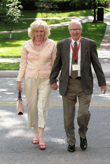 a man and woman holding hands and walking