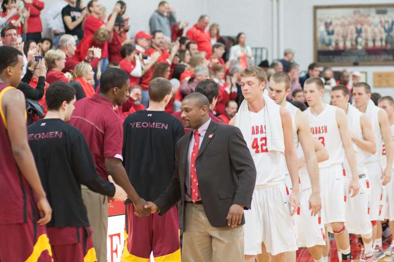 a basketball players shaking hands in front of a crowd