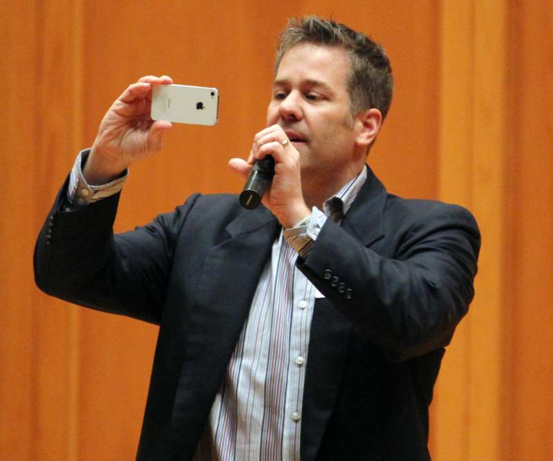 a man holding a phone and taking a picture of himself