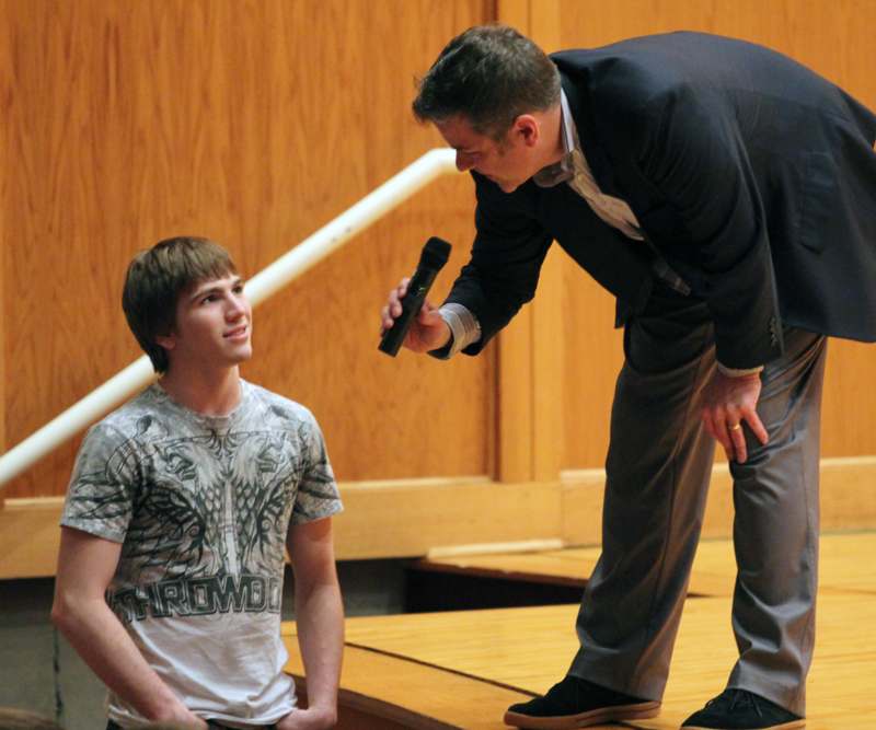 a man holding a microphone to a young man