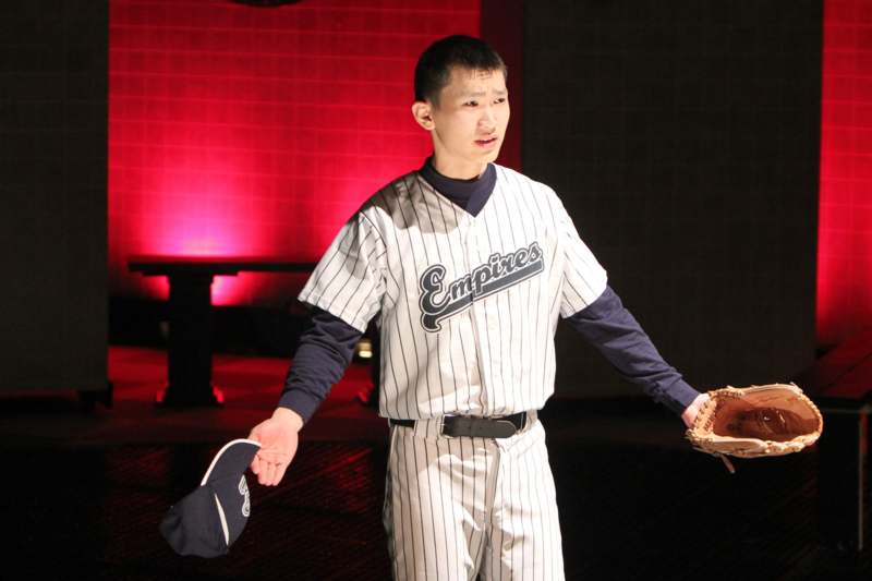 a man in a baseball uniform holding a baseball glove