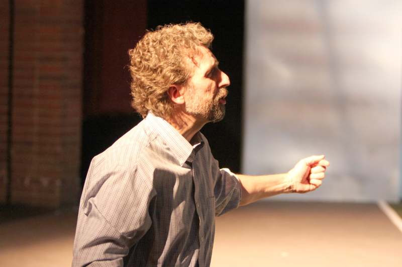 a man with curly hair pointing his finger