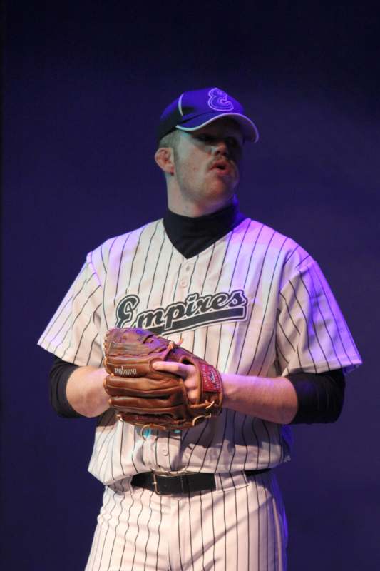 a man wearing a baseball uniform and glove