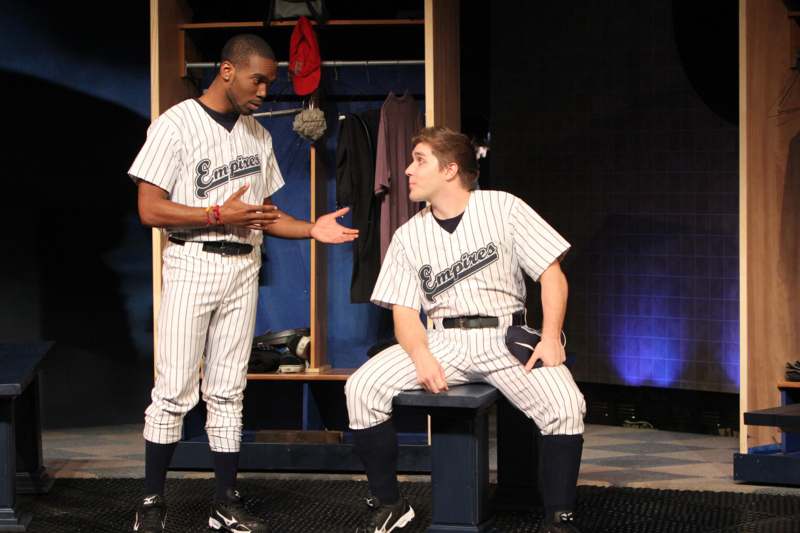 a man in a baseball uniform talking to another man