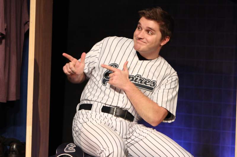 a man in a baseball uniform pointing at something