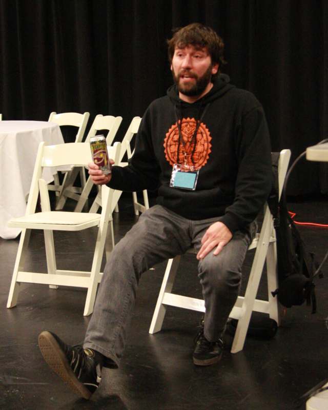 a man sitting in a chair holding a can