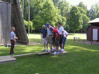 a group of people standing on a wooden plank