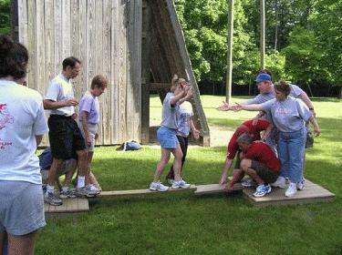 a group of people standing on a plank