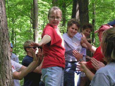 a group of people clapping in the woods