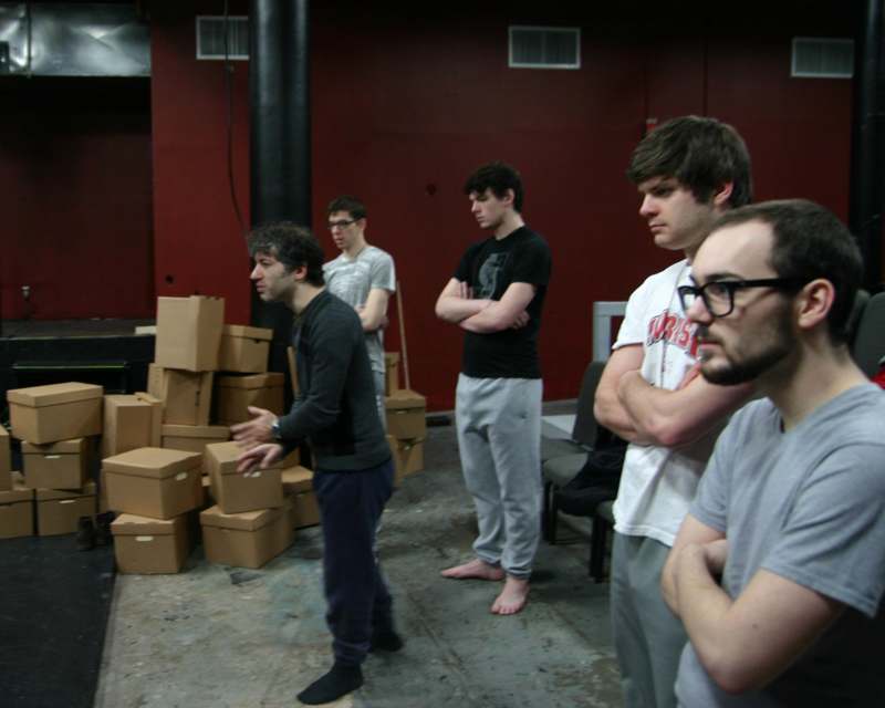 a group of men standing in a room with boxes