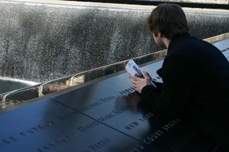 a man reading a book at a memorial