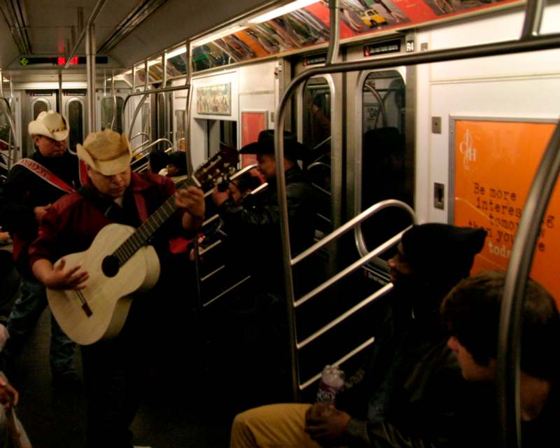 a group of people playing guitar on a train