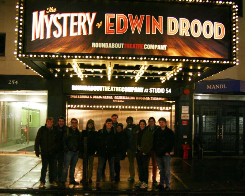 a group of people standing in front of a theater