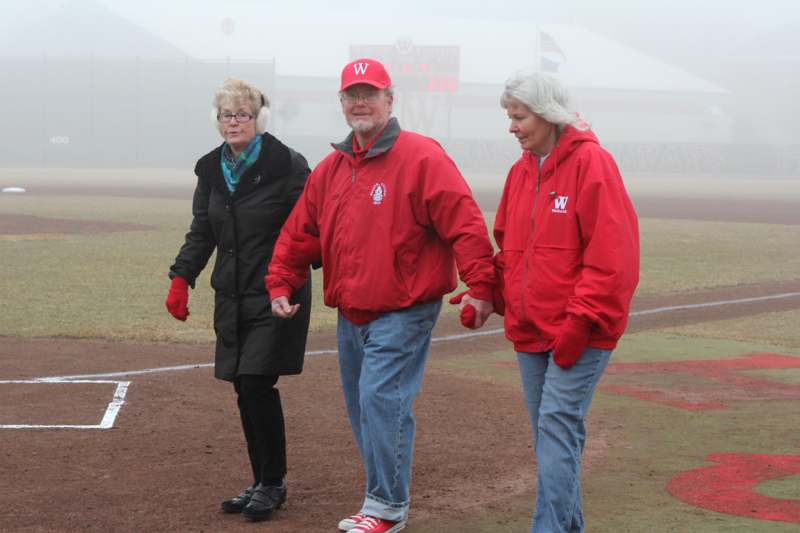 a group of people walking on a baseball field
