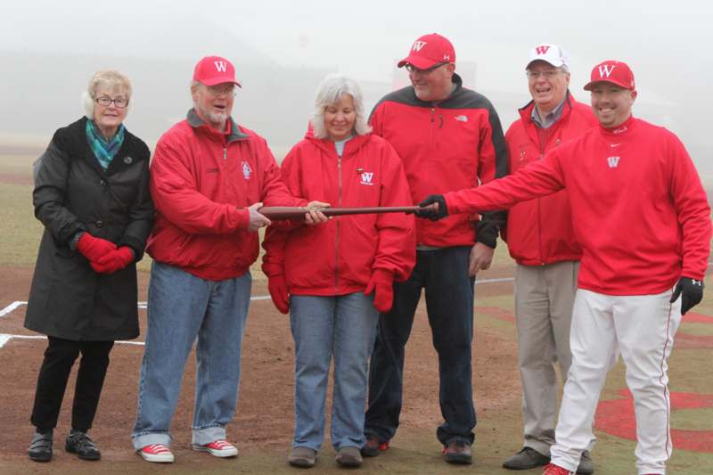 a group of people in red jackets holding a bat
