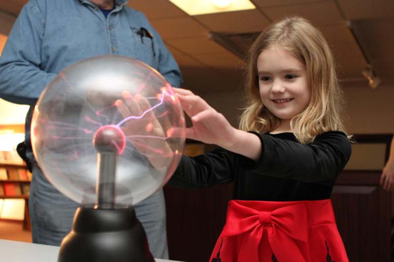 a girl touching a plasma ball