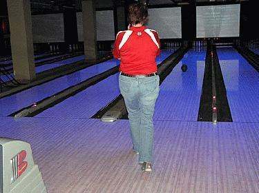 a woman walking down a bowling alley