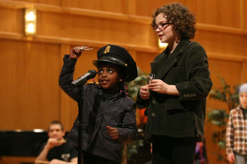 a young girl and a young girl standing next to a microphone