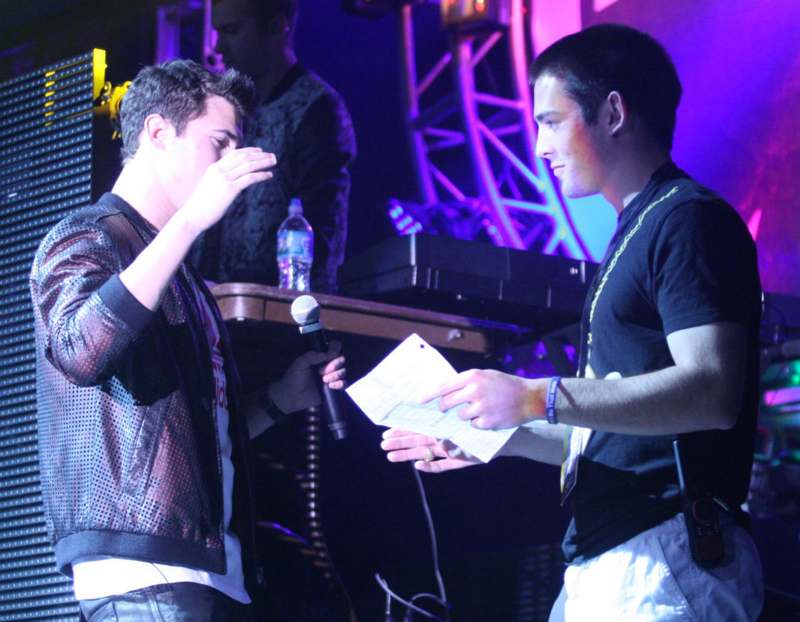 a man holding a microphone and another man holding a paper