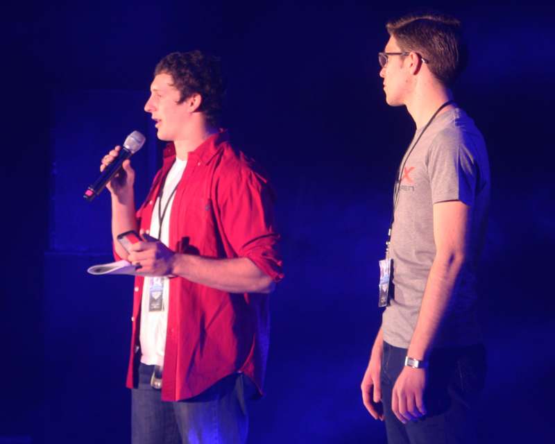 a man holding a microphone and another man standing next to him