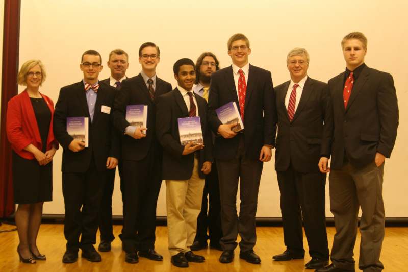 a group of men in suits holding books