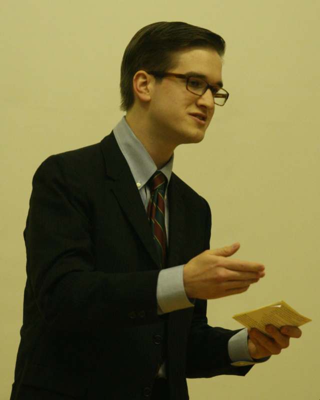 a man in a suit and tie holding a piece of paper