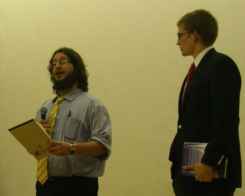 a man holding a microphone and a man holding a book