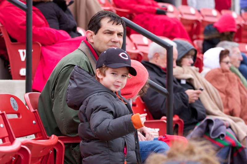 a man and child sitting in a stadium