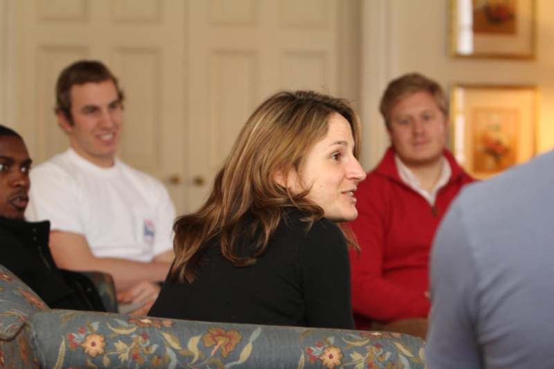 a woman sitting on a couch with other people in the background