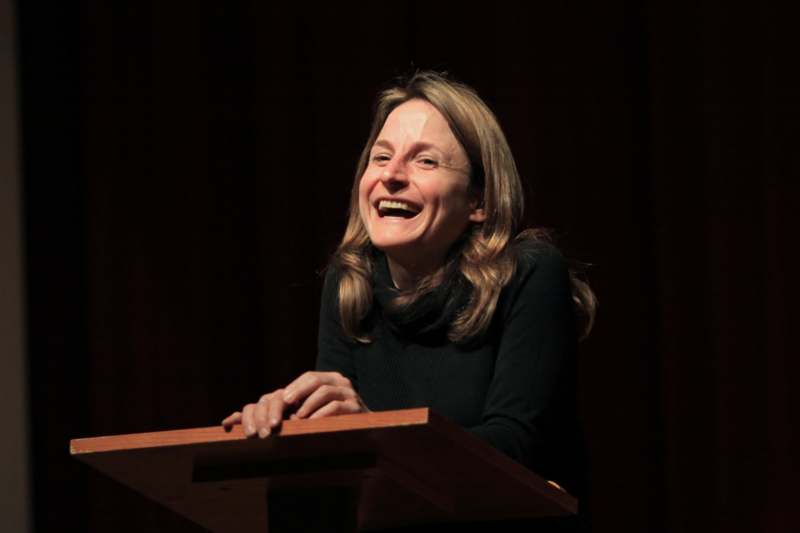 a woman laughing at a podium
