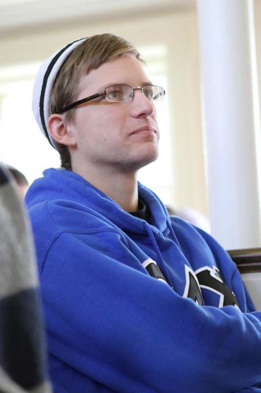 a man in a blue sweatshirt and glasses