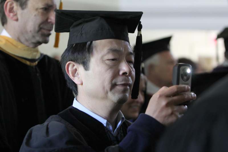 a man in a graduation gown taking a picture of himself