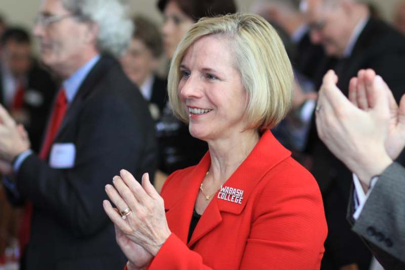a woman in a red jacket clapping