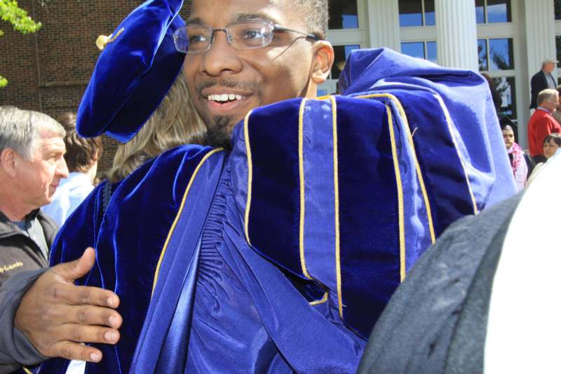 a man wearing a blue graduation gown