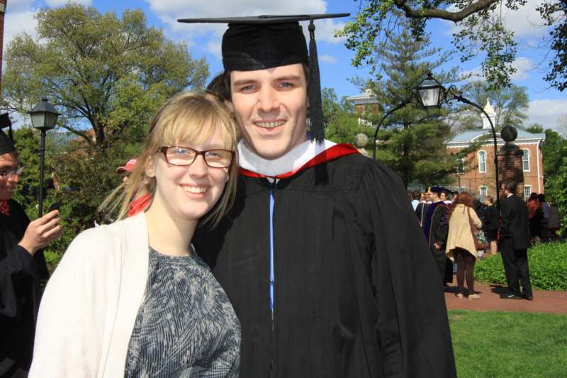 a man in a cap and gown with a woman in the background
