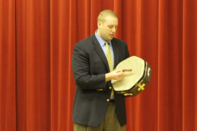 a man in a suit playing a drum