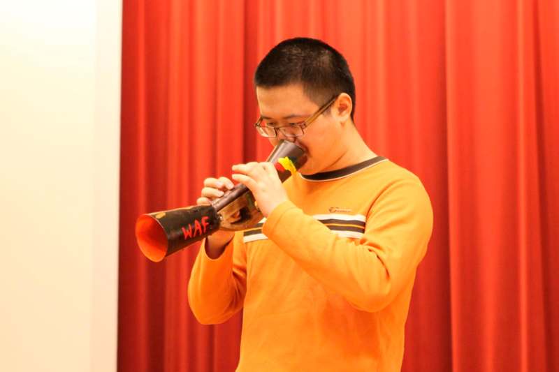 a man in a yellow shirt playing a trumpet