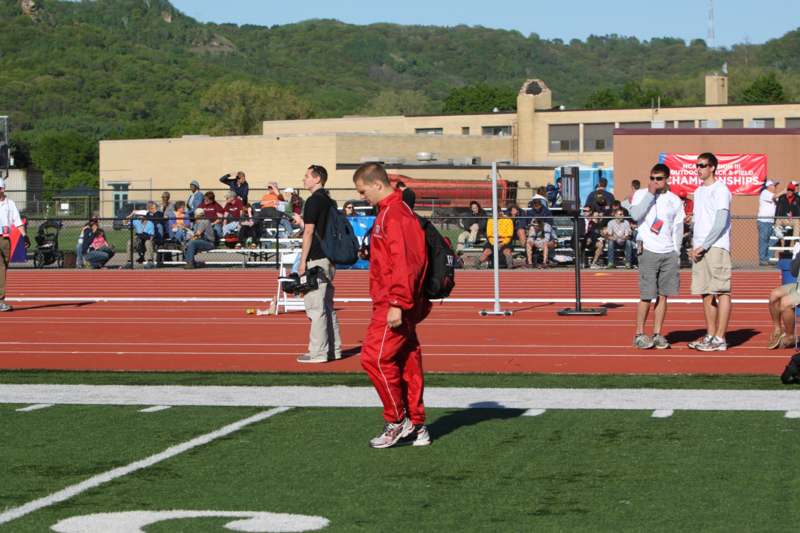 a man in red tracksuit walking on a track