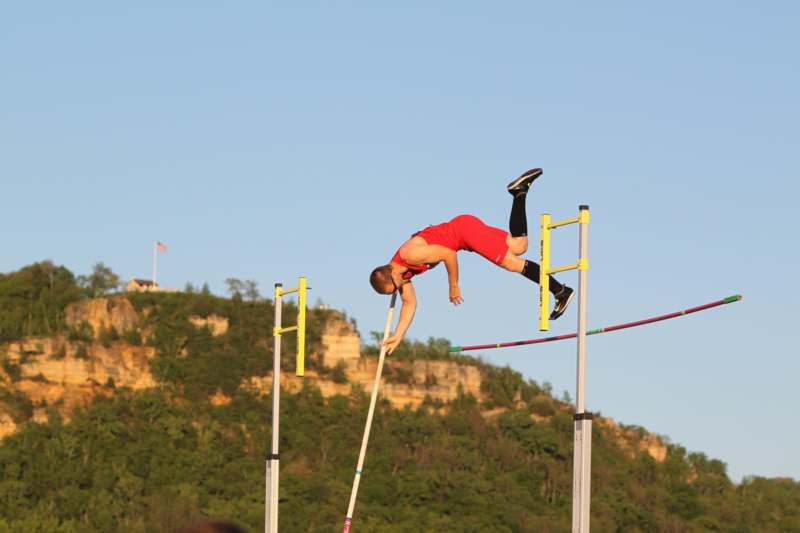 a man jumping over a pole