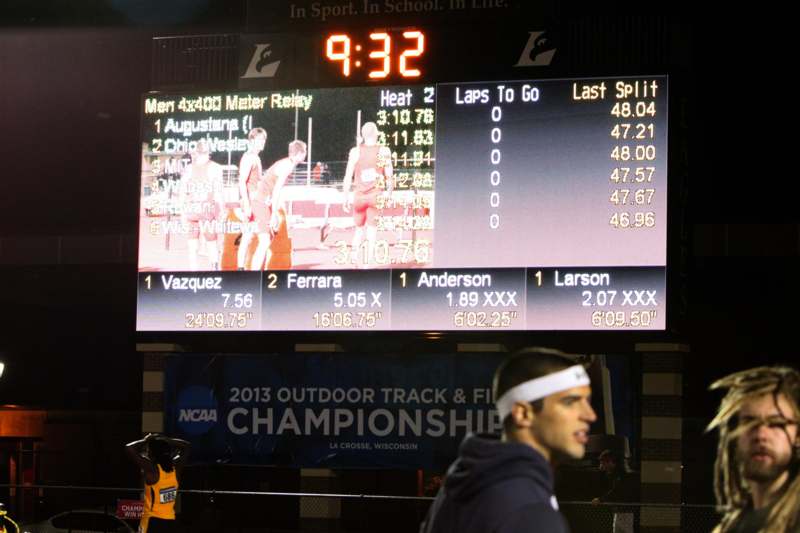 a man in a white headband standing in front of a scoreboard