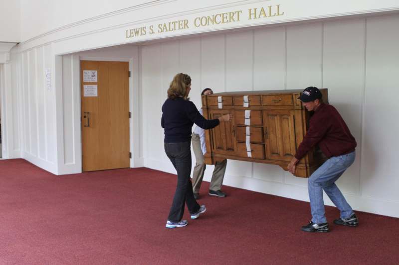 a group of people moving a large dresser
