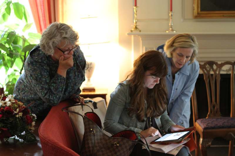 a group of women looking at a tablet