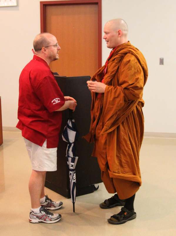 a man in a robe talking to another man