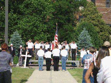 a group of people saluting at a memorial